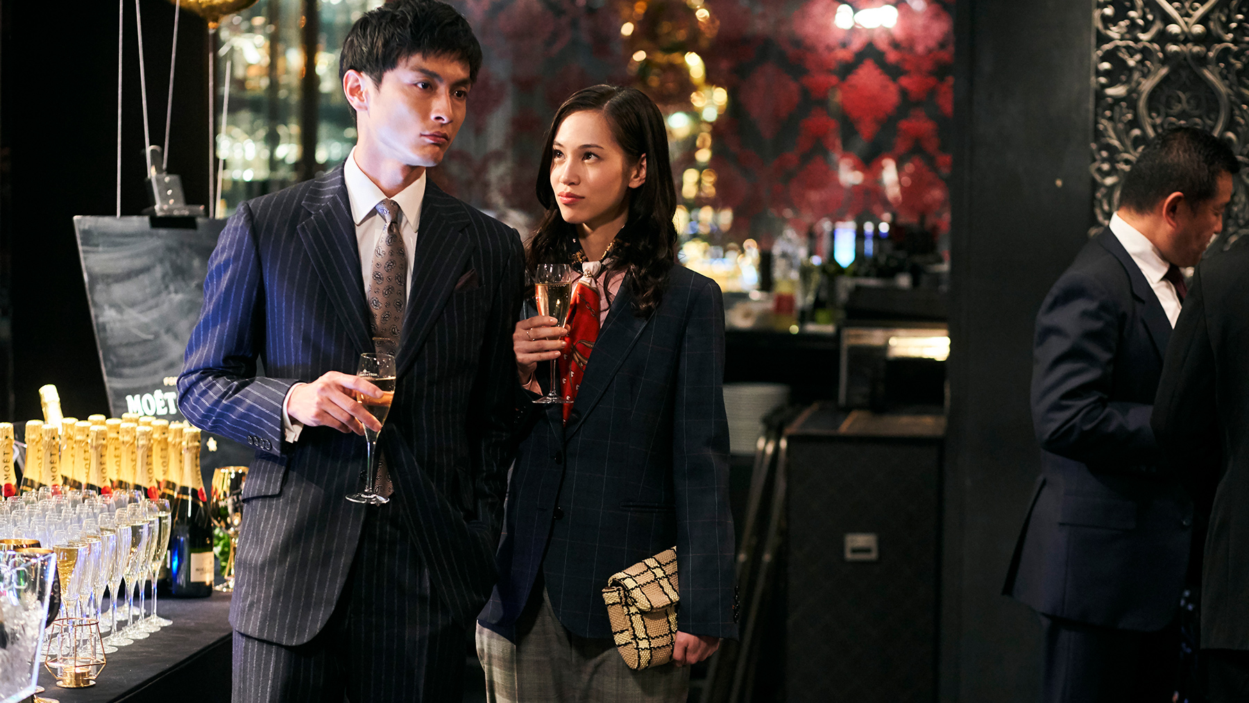 a man and woman holding glasses of champagne at a soiree