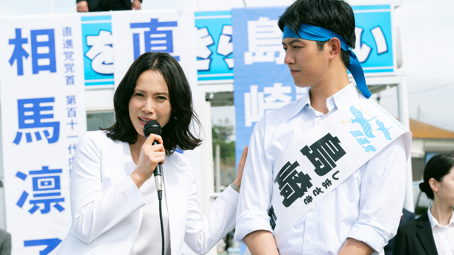 woman with microphone standing next to man