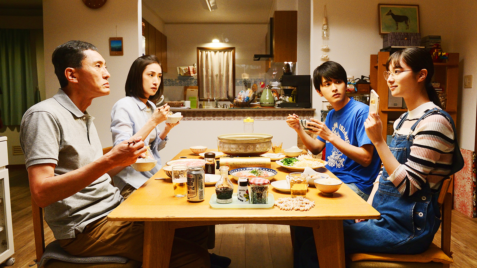 four people sitting around a table eating food