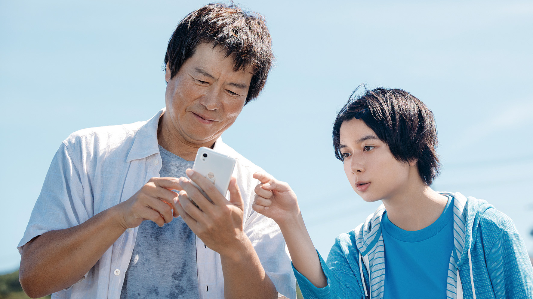 a child and adult looking at cell phone