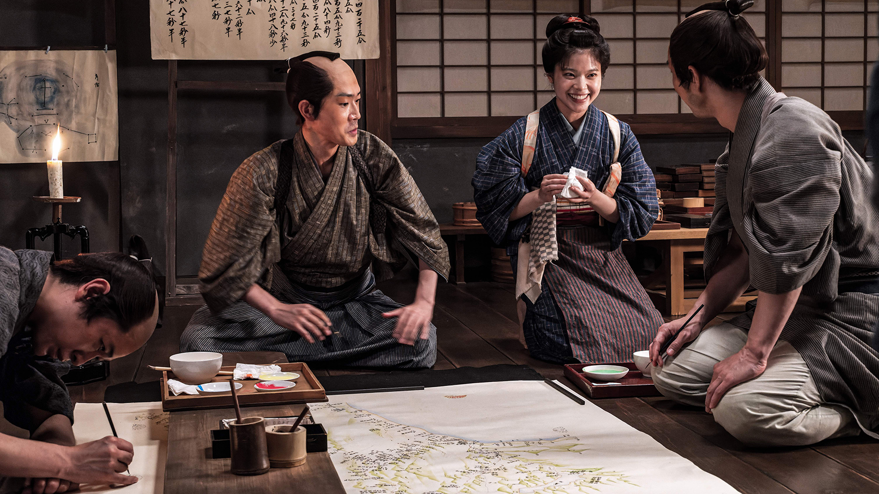 group of people sitting and talking around a map