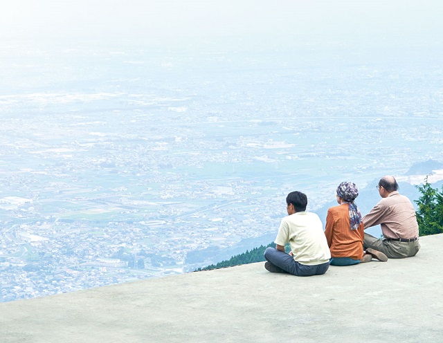 family sitting on rock
