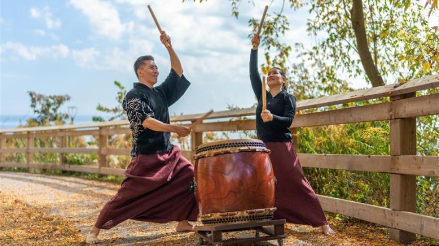 Two men play Taiko drum in tandem